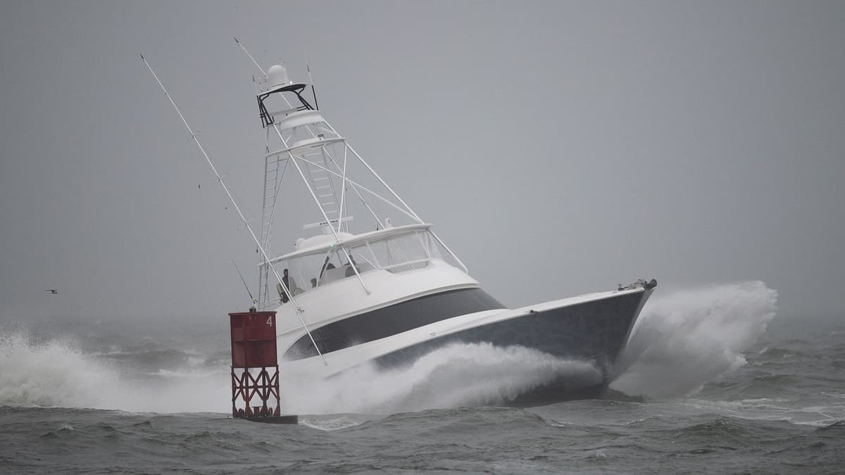 Sportfishing boat navigating rough waves near a buoy, showcasing its strength amidst turbulent waters