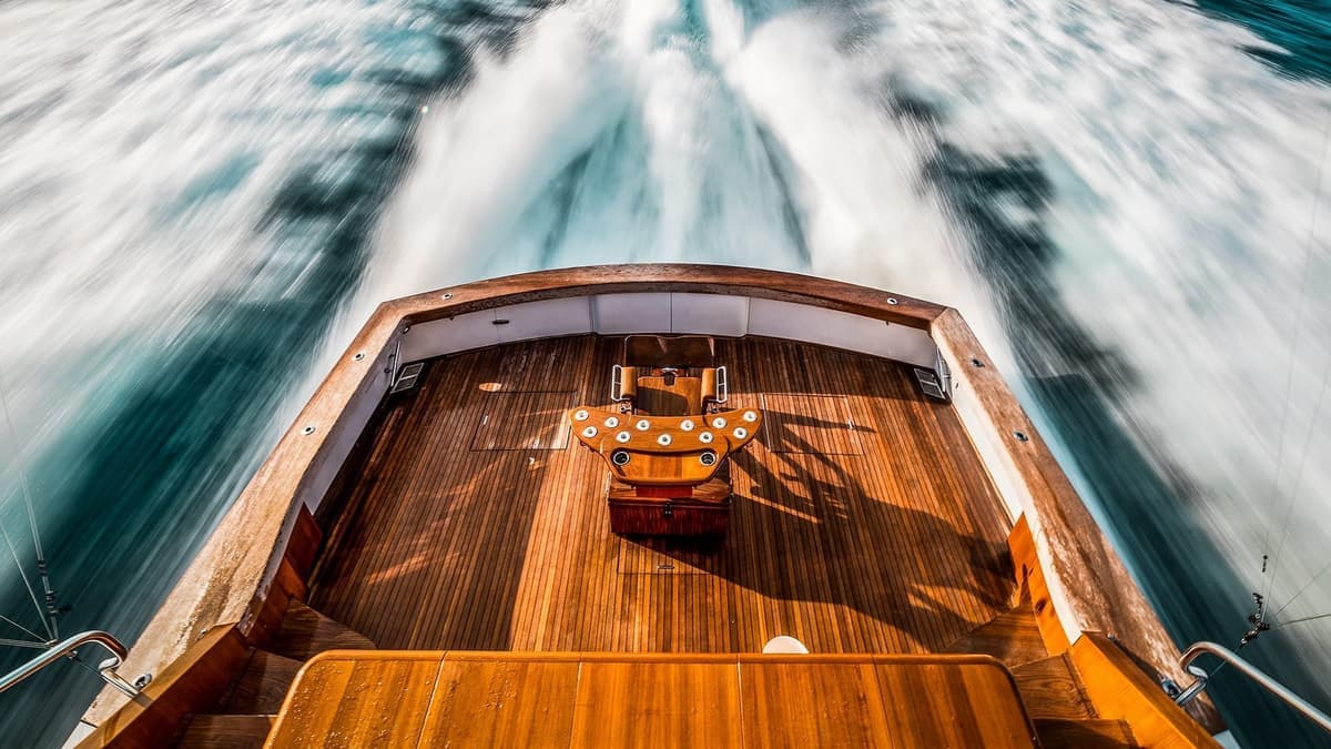 Aerial view of a sportfishing boat cruising at high speed with water trails behind it