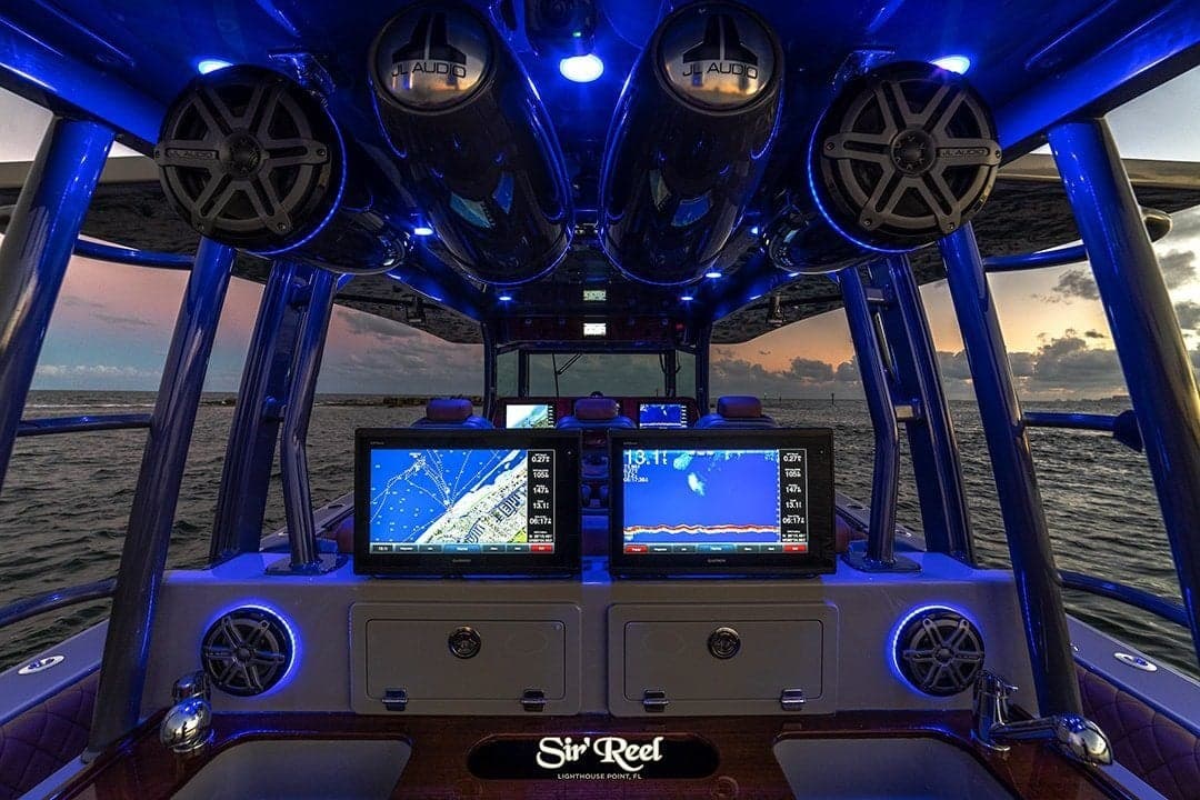 Interior of a modern sportfishing boat with advanced navigation and sonar systems, taken at sunset