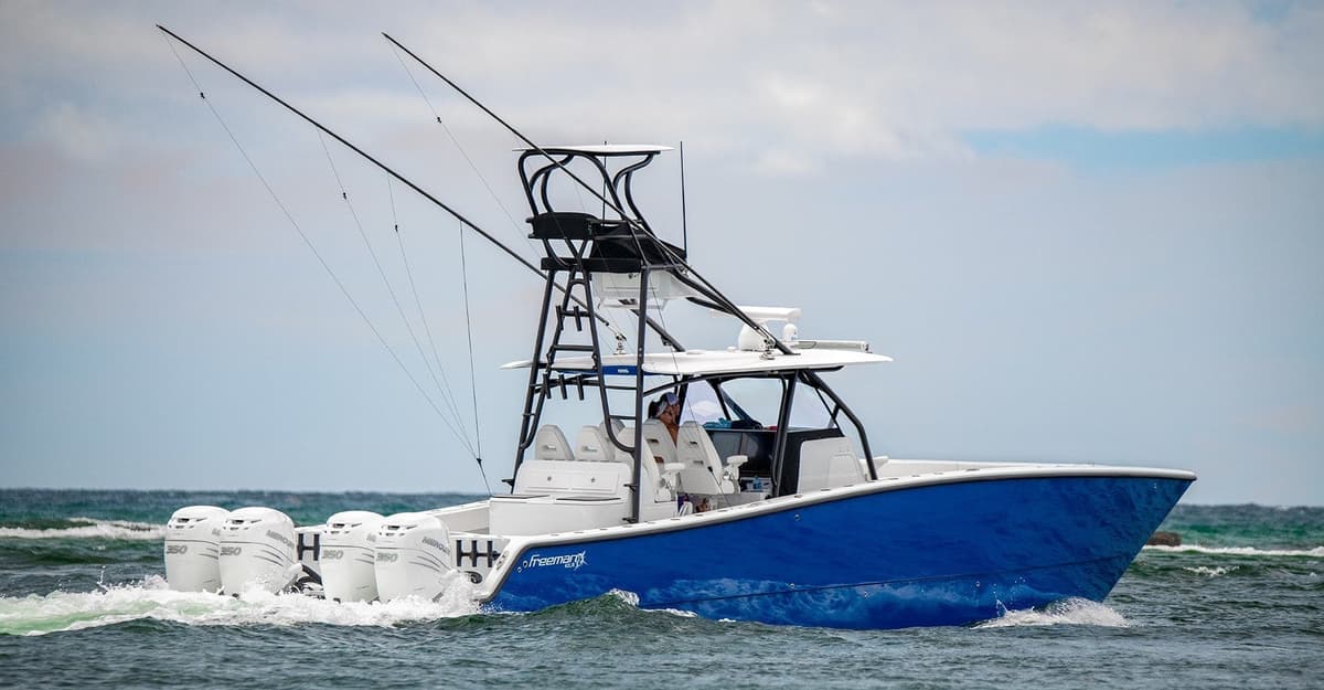 A vibrant blue sportfishing boat with multiple outboard engines cruising through the water