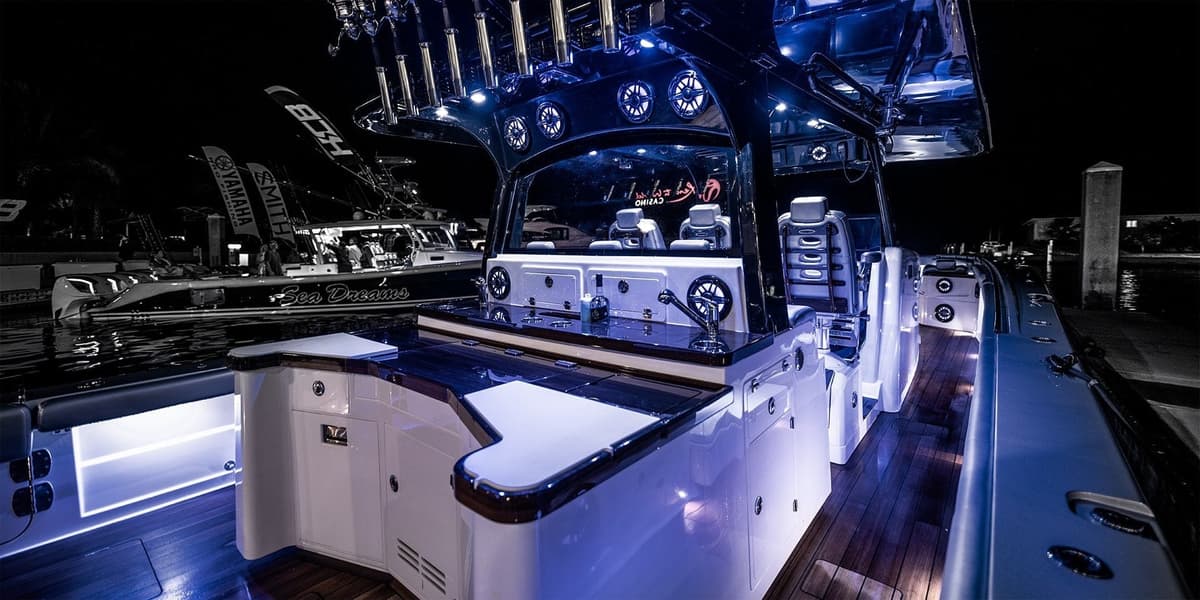 Illuminated sportfishing boat with advanced equipment, showcasing sleek design and luxury under night skies