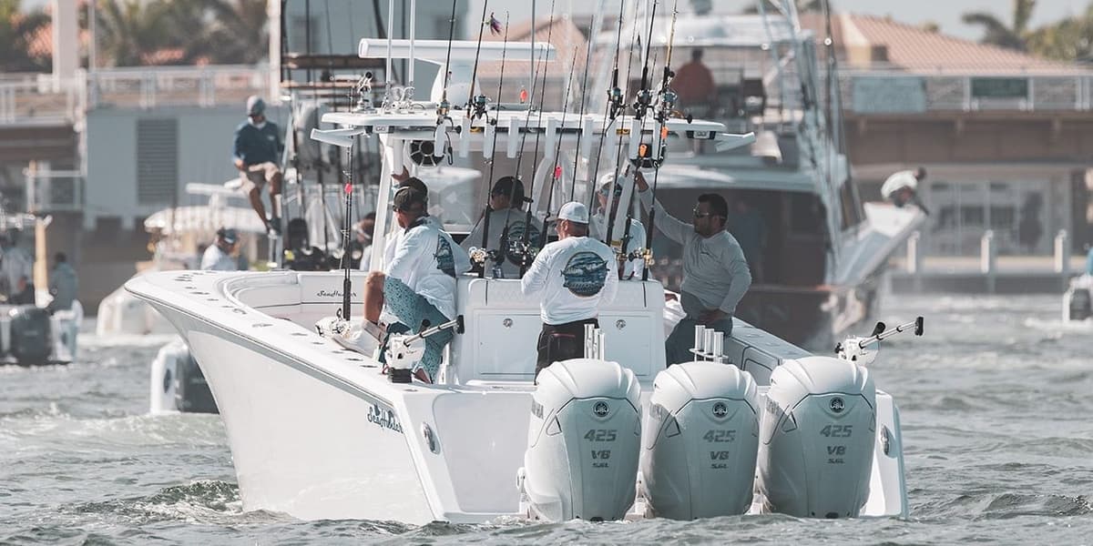 A dynamic sportfishing boat with multiple fishing rods cruising through waters with several anglers onboard