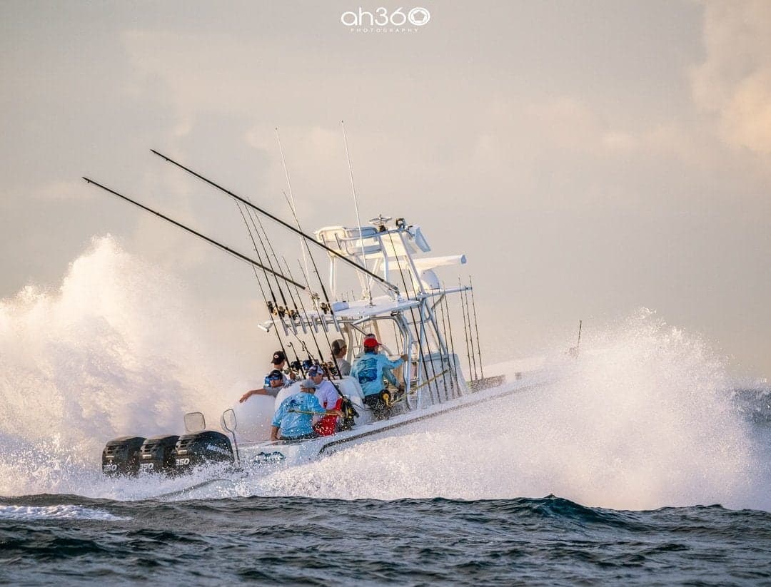 Sportfishing boat with multiple anglers navigating waves in dynamic offshore setting
