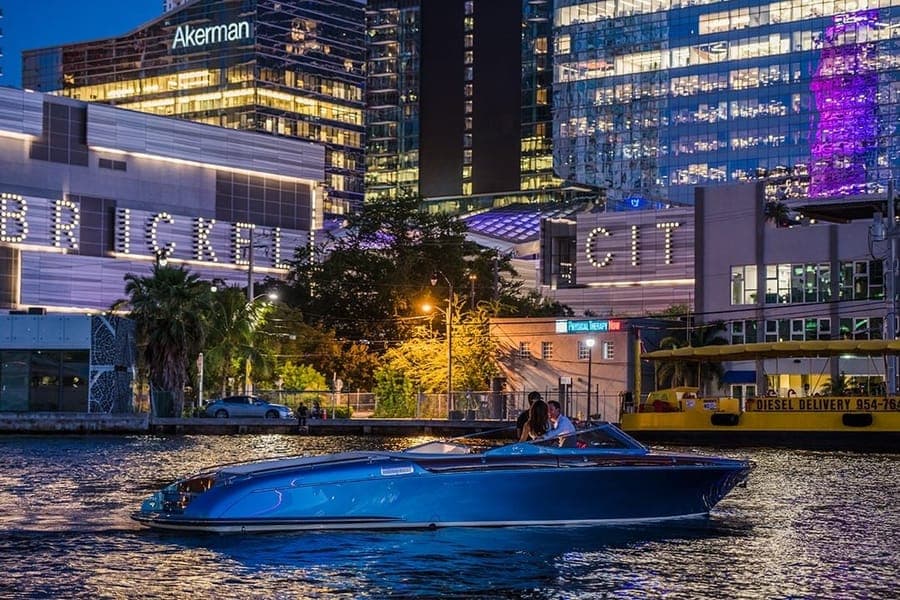 Blue runabout running at night in front of Brickell City Centre, Biscayne Bay, Miami