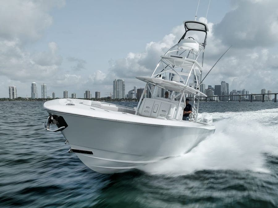Center console running with the Miami skyline behind, near Haulover Inlet — offshore action shot